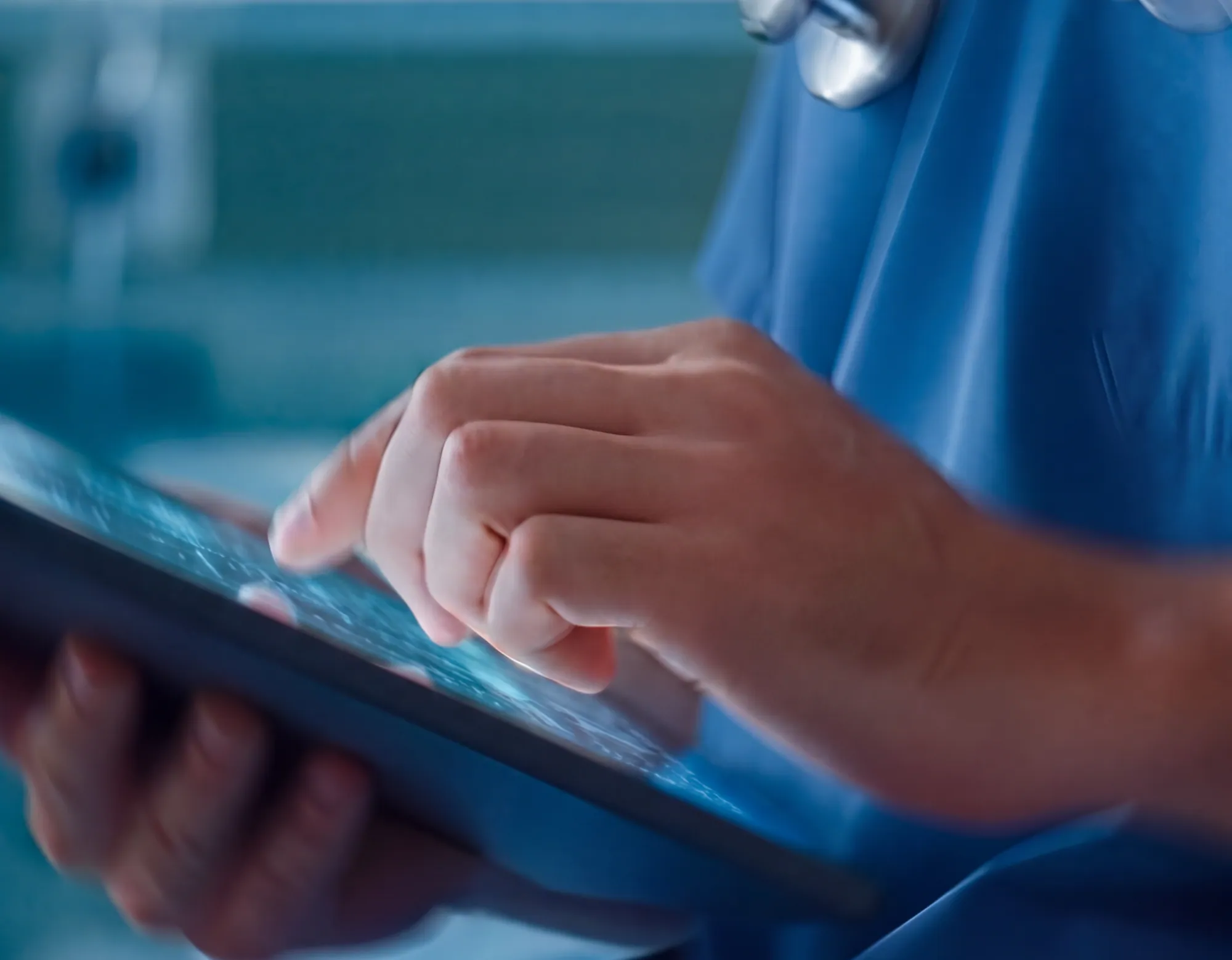 A clinician in scrubs using a tablet
